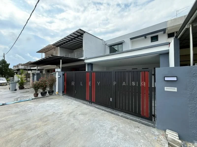 Exterior type: semi-detached house; features: black and red metal gate, concrete driveway, grey painted facade, two-storey structure, flat roof, landscaped garden with potted plants, car porch, exposed concrete walls, large windows, balcony on upper floor; style: modern.