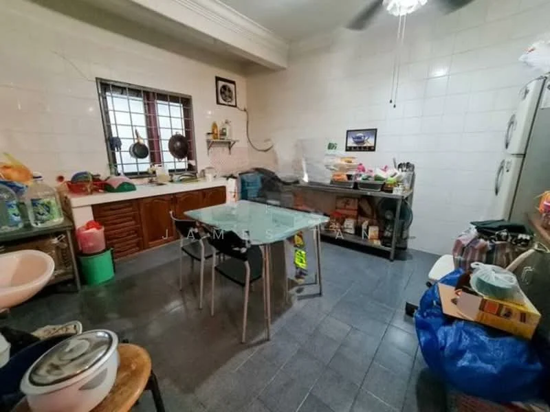 Kitchen features: white tiled walls, grey tiled flooring, wood cabinetry, stainless-steel sink, double-door fridge, freestanding gas stove, metal countertop, glass window with metal grille, ceiling fan, dining table with four chairs, various kitchen appliances, plastic storage containers.