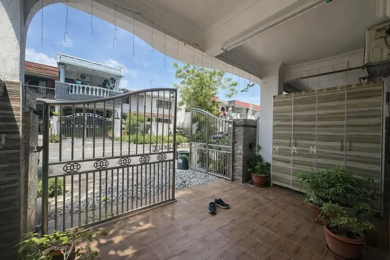Exterior type: linked terrace house; features: metal gate, paved walkway, landscaped garden with plants, stone pebbles, front porch area, two-storey house visible in background, mature trees, sunny outdoor space; style: modern.