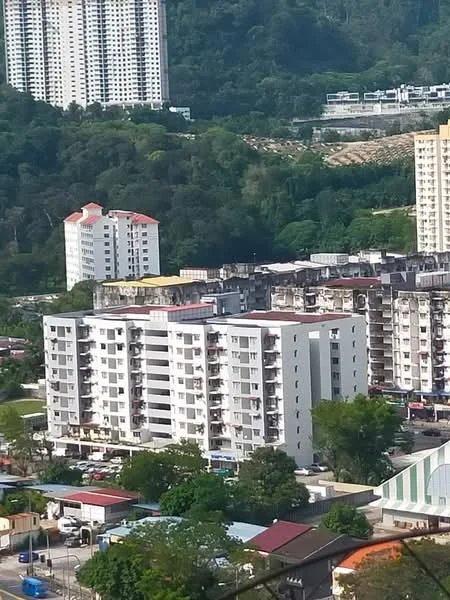 Exterior type: mid-rise condominium; features: white painted facade, balconies with railings, multiple storeys, surrounded by greenery, parking area visible, nearby high-rise buildings, red-tiled roof, landscaped garden, urban context with hills in background; style: modern.