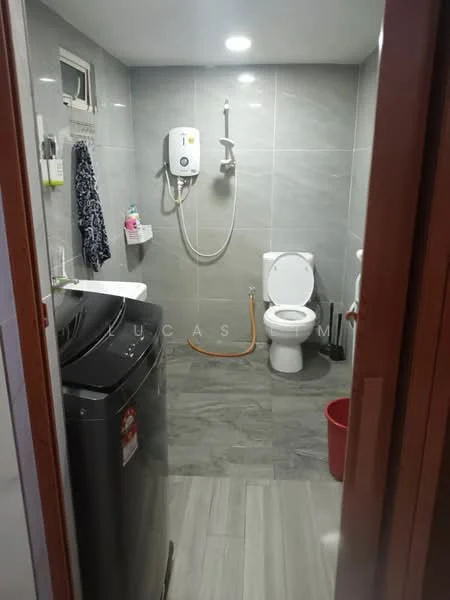 Laundry features: front-load washing machine, white toilet, shower with handheld faucet, grey tiled walls, grey tiled flooring, ceiling lights, white wall-mounted water heater, shelf for toiletries, red bucket; style: modern.