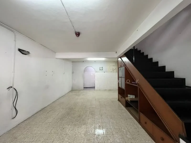 Room features: white painted walls, tile flooring, staircase with wooden railing, recessed ceiling light, open space layout, no visible furniture, wall-mounted light fixture, doorway leading to another room.