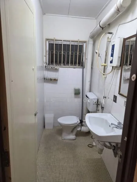 Bathroom features: white tiled walls, beige tiled flooring, one-piece toilet, wall-mounted sink, mirror above sink, shower head, water heater, window with security bars, towel rack, toilet paper holder.