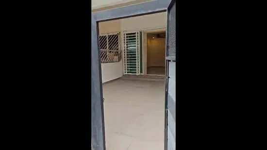 Room features: tiled flooring, neutral wall colour, large windows with security grills, open layout, doorway leading to another room, natural light, spacious area, no visible furniture; style: modern.