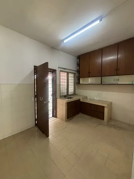 Kitchen features: brown wooden cabinetry, white tiled backsplash, single-bowl stainless-steel sink, chrome faucet, countertop with beige surface, floor tiles in light beige, window with metal grille, door leading outside, fluorescent ceiling light.