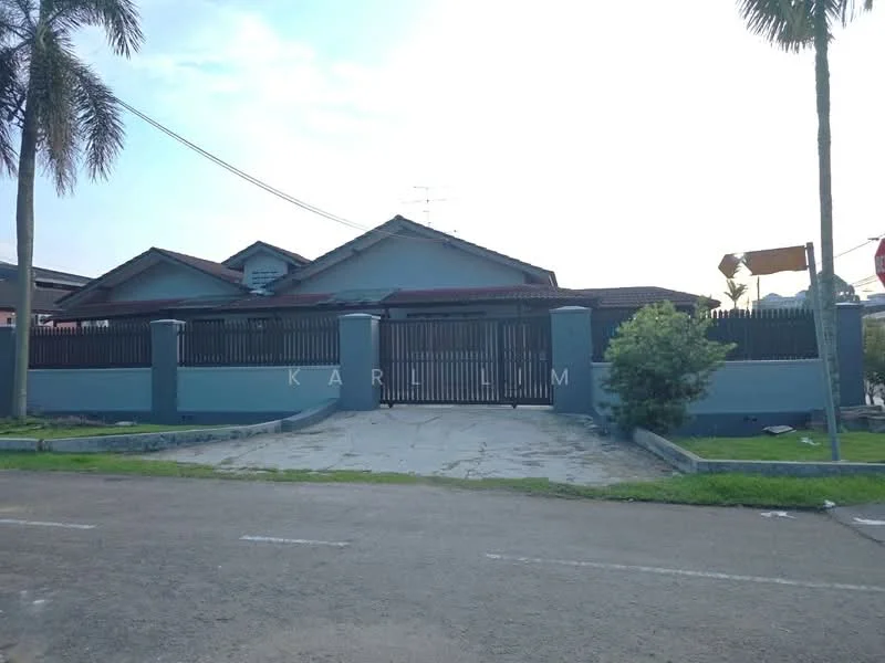 Exterior type: detached bungalow; features: grey painted facade, pitched tile roof, manicured lawn, palm trees, stone-paved driveway, fenced perimeter, gated entry, single-storey, front porch, visible parking area; style: modern.