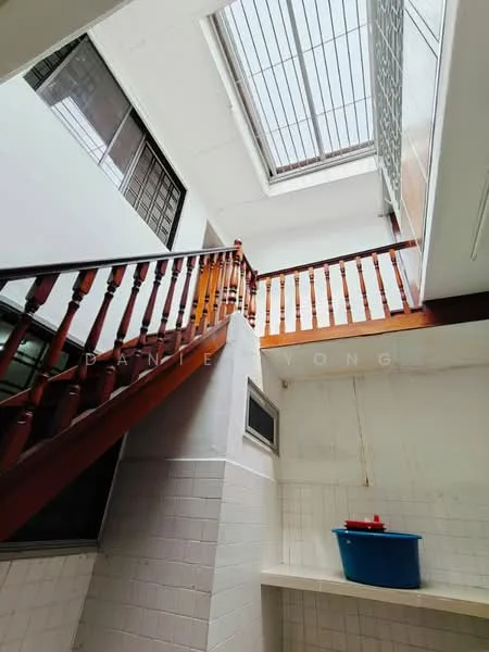 Room features: wooden staircase with handrail, white tiled walls, white ceiling, skylight, blue plastic bucket, window with metal grille, open space, natural light; style: modern.