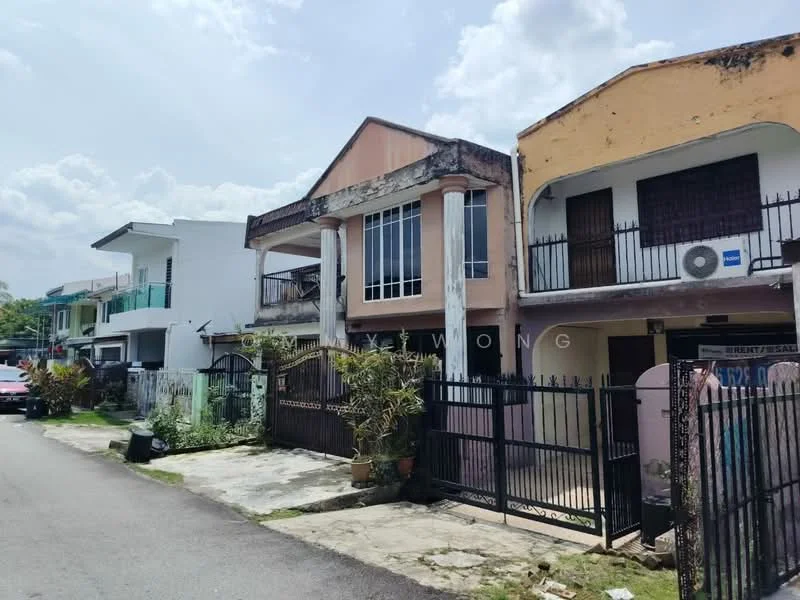 Exterior type: linked terrace house; features: two-storey building, pink painted facade, balcony with glass railing, metal gate, fenced perimeter, air conditioning unit visible, driveway, surrounding greenery, concrete pathway, street view, adjacent buildings visible; style: traditional.