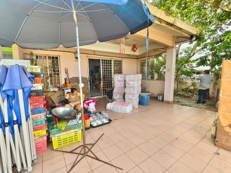 Exterior features: covered patio area, tile flooring, outdoor storage boxes, large umbrella for shade, surrounding greenery, open space, fenced area, multiple storage crates.