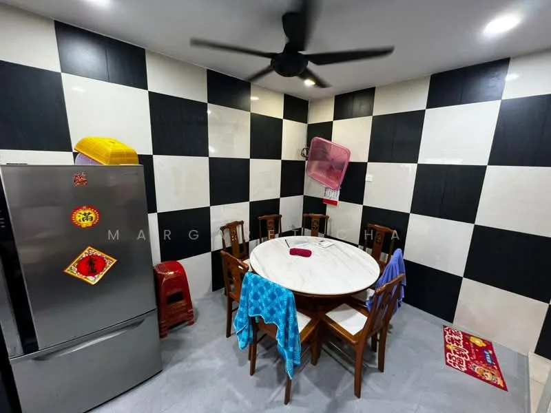 Kitchen features: round dining table, wooden dining chairs, stainless-steel fridge, black and white checkered wall tiles, grey floor tiles, ceiling fan, decorative wall hanging, blue tablecloth, red plastic stools, colorful mat on the floor; style: modern.