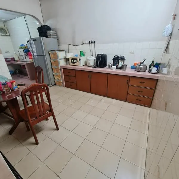 Kitchen features: brown wooden cabinetry, pink countertop, white tiled walls, cream tiled flooring, stainless-steel fridge, microwave, coffee machine, electric kettle, toaster, dining table with four wooden chairs, open shelving, sink, wall-mounted electrical outlets.