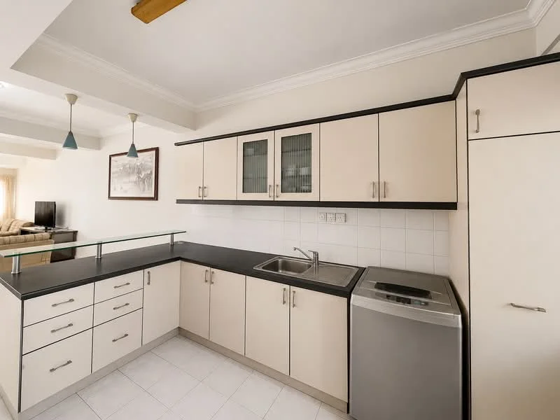 Kitchen features: cream cabinetry with glass-front upper cabinets, black countertop, stainless-steel single-bowl sink, chrome pull-down faucet, built-in washing machine, white tiled backsplash, white tiled flooring, recessed downlights, ceiling fan with light, open shelving, kitchen island with glass railing; style: modern.