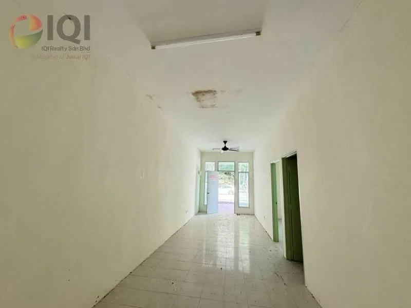 Room features: white painted walls, tile flooring, ceiling fan, single light fixture, large windows, doorway leading outside, green door frames, unpainted ceiling with stains; style: minimalist.