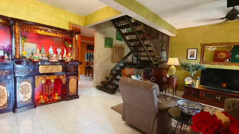 Living features: green painted walls, white tiled flooring, wooden staircase, decorative wooden console with carvings, wall-mounted TV, sofa with armchair, coffee table, area rug, table lamp, houseplants in ceramic pots, framed artwork, ceiling fan; style: traditional. Dining features: dining table, chairs, decorative items on table; style: traditional.