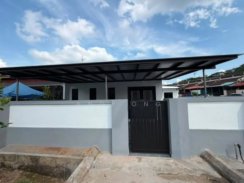 Exterior type: detached bungalow; features: flat roof, white painted facade, grey accent wall, black metal gate, covered porch area, manicured lawn, surrounded by low fencing, windows with black frames; style: modern.