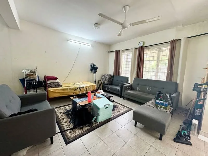 Living features: 3-seater fabric sofa in grey, 2-seater fabric sofa in grey, coffee table, area rug with geometric pattern, ceiling fan, wall-mounted light fixture, curtains, tile flooring, wall with white paint, window with view to outside, vacuum cleaner, foldable bed, fan.
