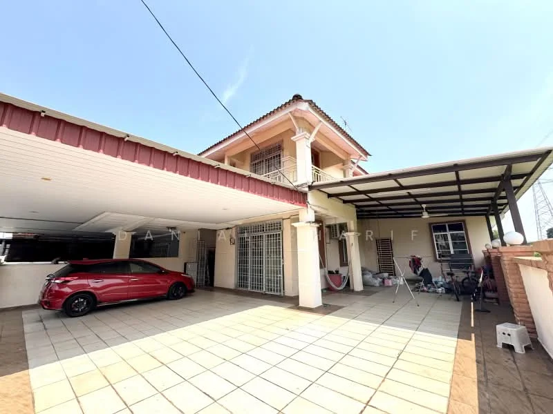 Exterior type: semi-detached house; features: red car parked in driveway, covered car porch, paved driveway, two-storey structure, balcony on upper floor, metal roof, white painted facade, large windows, outdoor lighting, manicured garden area, fence surrounding property; style: modern.