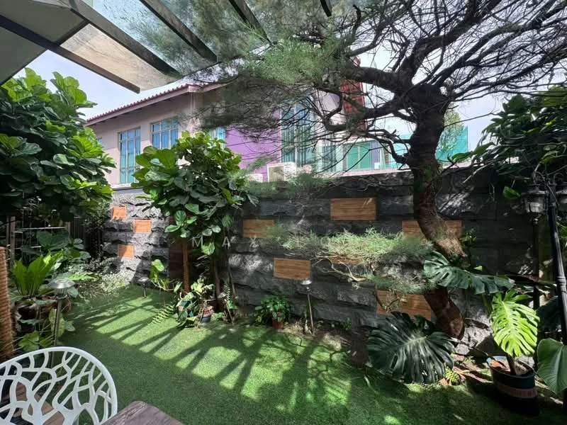Exterior features: manicured lawn, mature trees, tropical landscaping, stone wall, decorative planters, outdoor seating area, covered patio, greenery, fenced garden; style: tropical-modern.