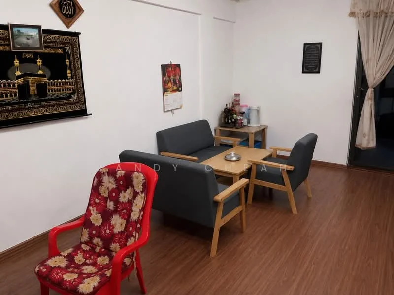 Living features: laminate flooring, white painted walls, sofa with grey upholstery, wooden coffee table, wooden side table, decorative wall art, curtains, framed wall plaque, red plastic chair with floral pattern, bottle rack, water dispenser.
