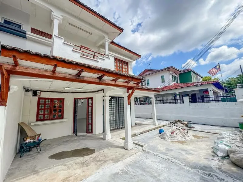 Exterior type: semi-detached house; features: white painted facade, red window frames, terracotta roof tiles, covered porch area, concrete flooring, fenced yard, manicured landscaping, adjacent houses visible, American flag visible, outdoor storage area; style: traditional.