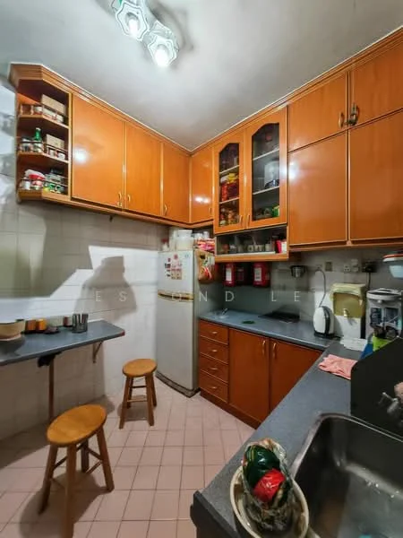 Kitchen features: wood cabinetry in orange finish, grey laminate countertop, stainless-steel sink, chrome faucet, built-in refrigerator, wall-mounted shelves, stool seating, tile flooring in pink, overhead fluorescent lighting, white tiled walls; style: traditional.