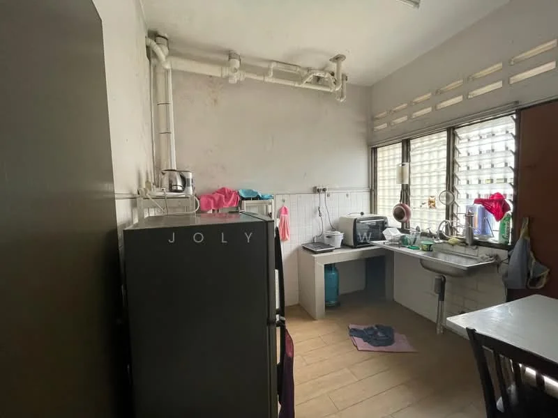 Kitchen features: grey refrigerator, single-bowl stainless-steel sink, chrome faucet, white tiled backsplash, white walls, brown wooden dining table, tile flooring, window with grid pattern, kitchen countertop, visible plumbing pipes.