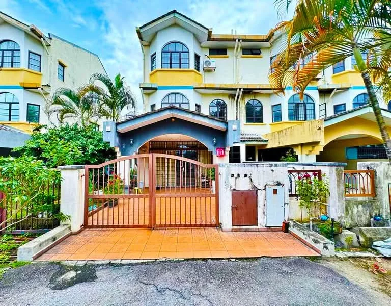 Exterior type: linked terrace house; features: two-storey building, yellow and white painted facade, arched entrance with gate, tiled driveway, manicured garden with plants, palm trees, balconies on upper floor, security grille at entrance, visible parking area, surrounded by greenery; style: modern.