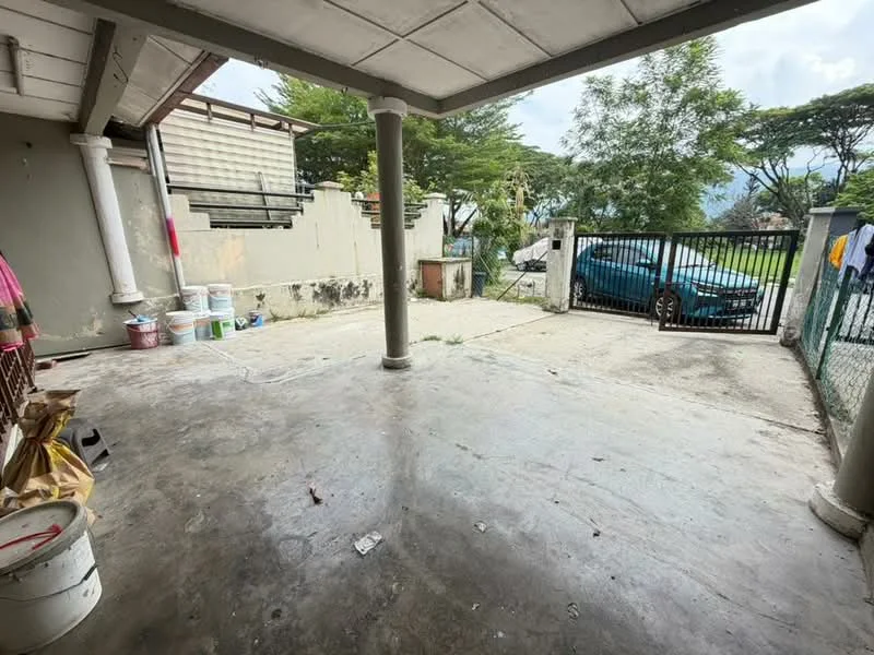 Exterior features: concrete flooring, covered porch area, metal gate, surrounding greenery, fenced perimeter, parking space, partially finished walls, outdoor area with potential for landscaping.