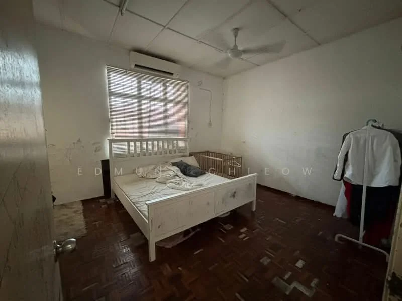 Bedroom features: wooden flooring, white painted walls, ceiling fan, window with blinds, single bed frame, mattress, crib, clothes rack, unmade bed, light fixture, exposed ceiling, wall with marks.