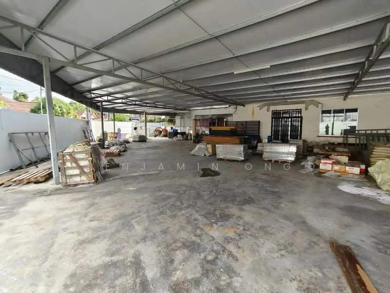 Exterior features: metal roof, concrete flooring, open space, storage materials scattered, partially enclosed area, exposed beams, surrounding walls, natural light from openings; style: industrial.