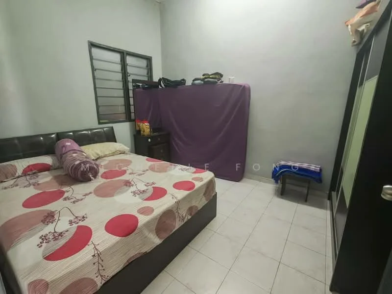 Bedroom features: queen-size bed with patterned bedspread, upholstered headboard, wooden bedside table, window with metal grille, light grey painted walls, white tiled flooring, purple fabric partition, stack of towels, black wardrobe with sliding doors, small folding chair.