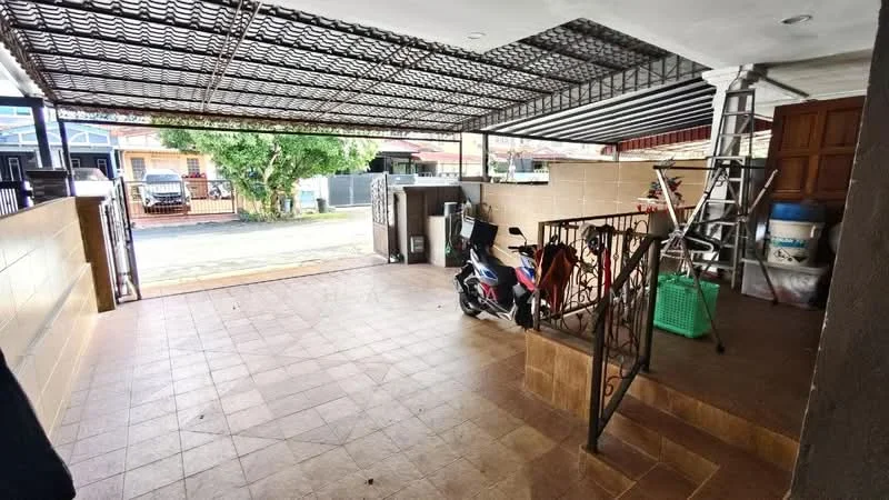 Exterior type: linked terrace house; features: covered car porch, tiled flooring, metal gate, decorative wrought iron railing, staircase leading to elevated area, ladder visible, green storage basket, motorcycle parked, exposed brick wall, surrounding greenery; style: modern.