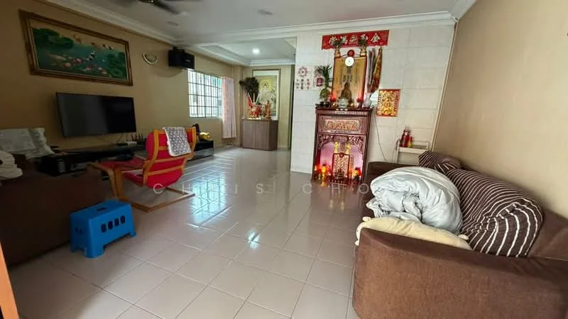 Living features: white painted walls, glossy tile flooring, sofa in brown fabric, armchair in red and yellow fabric, TV console with wall-mounted TV, decorative wall art, coffee table, decorative altar with candles and ornaments, window with sheer curtains, ceiling fan, area rug, throw blankets; style: traditional.
