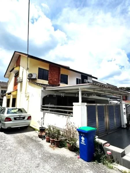 Exterior type: semi-detached house; features: two-storey structure, cream painted facade, red brick accent wall, flat roof, car porch with awning, visible air conditioning unit, manicured garden with potted plants, driveway with gravel surface, blue recycling bin, parking space for one car; style: modern.