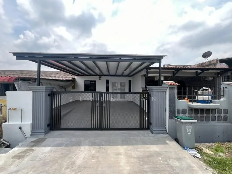 Exterior type: semi-detached house; features: metal gate, car porch with awning, flat roof, grey painted facade, exposed beams, manicured lawn, paved driveway, surrounded by residential area; style: modern.