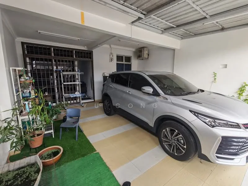 Exterior type: linked terrace house; features: car porch with interlocking pavers, grey painted facade, single-storey, manicured lawn, potted plants, air conditioning unit visible, sliding glass door, outdoor seating area with chair, green grass patch; style: modern.