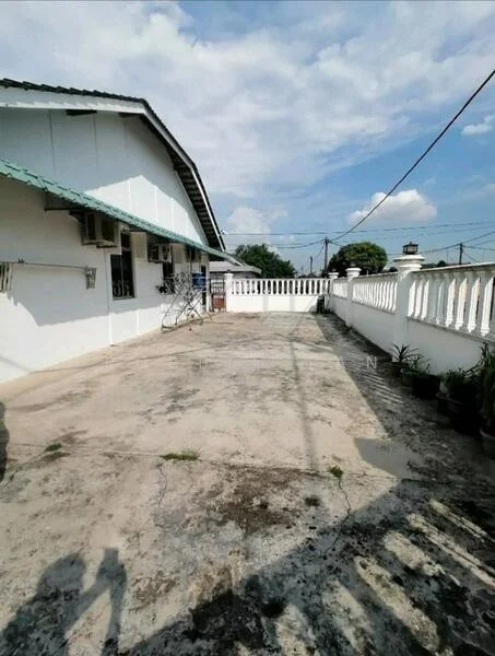 Exterior type: detached bungalow; features: white painted facade, flat roof, concrete flooring, manicured garden with potted plants, fenced perimeter, outdoor space with ample sunlight, visible air conditioning units, surrounded by open space; style: modern.