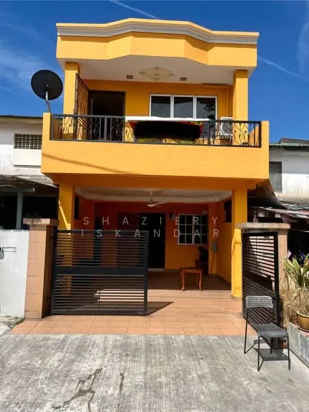 Exterior type: semi-detached house; features: yellow painted facade, balcony with railing, satellite dish on roof, ground floor porch, tiled flooring at entrance, black metal gate, outdoor seating area, manicured landscaping, concrete driveway, two-storey structure; style: modern.
