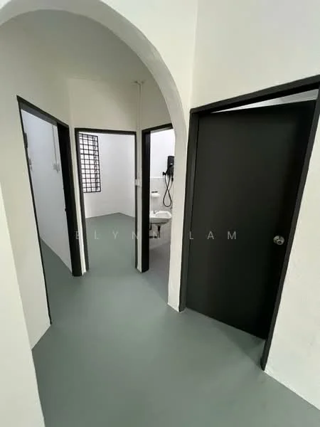 Room features: arched doorway, grey flooring, white painted walls, black doors, window with grid pattern, visible bathroom fixtures, light fixture on wall, door frames with black finish; style: modern.
