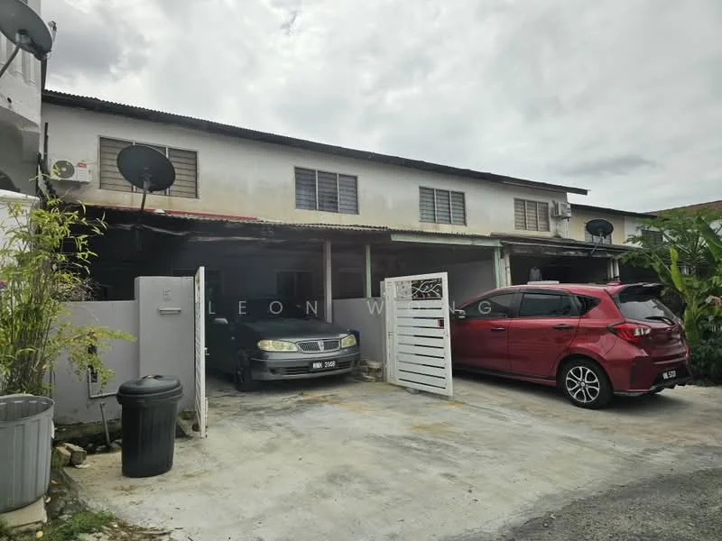 Exterior type: linked terrace house; features: two-storey building, grey painted facade, flat roof, two visible parking spaces, car porch with gate, satellite dishes on roof, manicured greenery, driveway with concrete surface; style: modern.