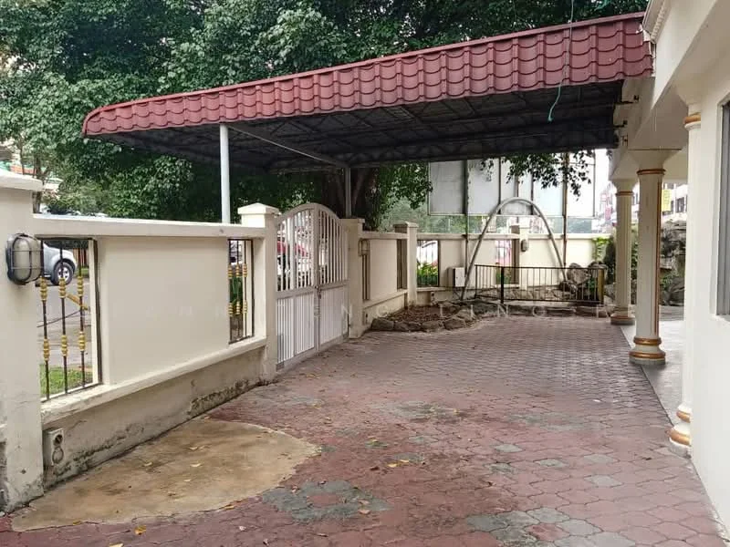 Exterior type: detached bungalow; features: covered car porch with red tiled roof, paved driveway with interlocking pavers, white painted fence, metal gate, manicured landscaping with trees, outdoor seating area, garden area with soil, wall-mounted outdoor lighting; style: traditional.