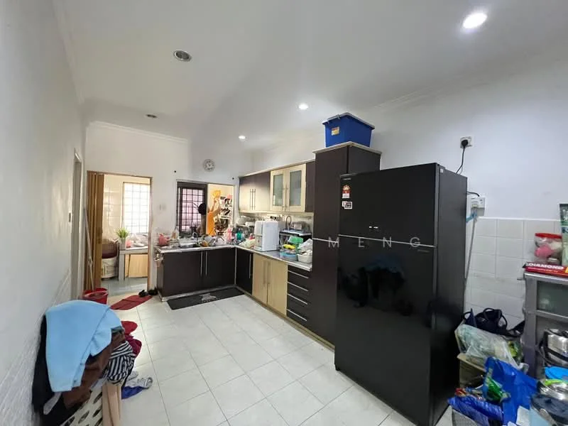 Kitchen features: white painted walls, tile flooring, ceiling lights, kitchen cabinets in wood and cream, black refrigerator, stainless-steel sink, countertop with space for appliances, kitchen island, various kitchen appliances visible, open shelving, multiple bags and items on the floor; style: modern.