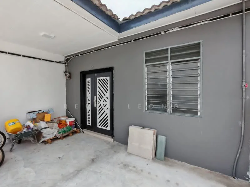 Room features: grey painted walls, concrete flooring, metal door with decorative grille, sliding windows, exposed ceiling, storage items including boxes and tools.