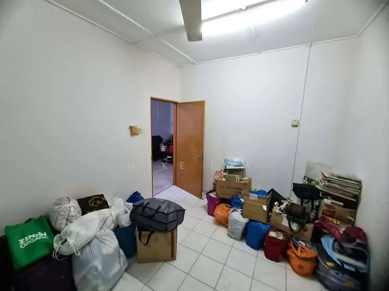 Room features: white painted walls, tile flooring, ceiling light fixture, wooden door, cluttered with bags and boxes.