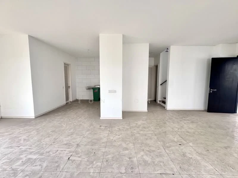 Room features: white painted walls, light grey floor tiles, open layout, staircase visible in background, doorway leading to another room, green trash bin, no visible furniture or decor; style: minimalist.