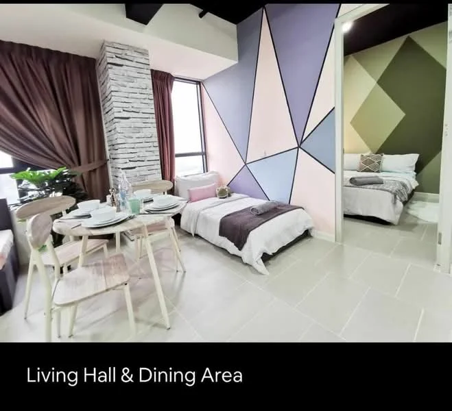 Living features: geometric accent wall with pink, green, and beige colors, white stone feature wall, large windows with city view, grey tiled flooring, wooden dining table with chairs, decorative table setting with plates and glasses, sofa bed with grey and white bedding, potted plant, curtains in dark brown, wall-mounted light fixtures; style: modern; view: city. Room features: bed with white and grey bedding, decorative pillows, neutral wall colors, doorway leading to another room.