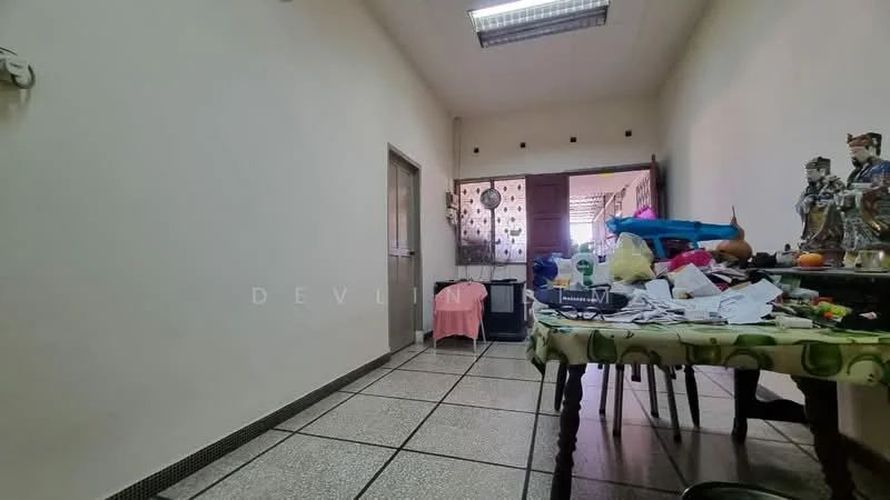 Room features: white painted walls, tile flooring, ceiling lights, wooden door, table with clutter, decorative items on table, open doorway, window with curtain.