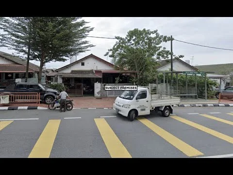 Exterior type: linked terrace house; features: single-storey, white painted facade, red tiled roof, manicured lawn, mature trees, paved walkway, front porch, car parking area, street view with yellow pedestrian crossing, adjacent to main road; style: traditional.