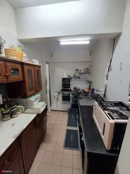 Kitchen features: single-bowl stainless-steel sink, chrome pull-down faucet, black countertop, built-in oven, freestanding range oven, microwave, wood cabinetry with glass-front upper cabinets, tile flooring, recessed ceiling lights, wall-mounted shelves, kitchen utensils and appliances visible; style: modern.