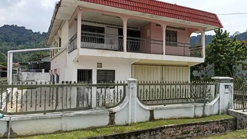 Exterior type: detached bungalow; features: white painted facade, red pitched tile roof, balconies with railings, fenced perimeter, manicured lawn, mature trees, two-storey structure, front porch, driveway, window grilles; style: traditional.